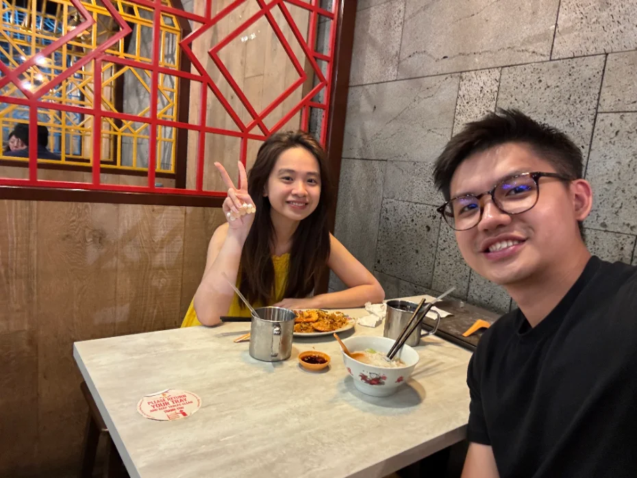Priscillia and Nicholas smiling at a table over lunch